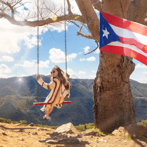 woman on swing with Puerto Rican Flag blowing