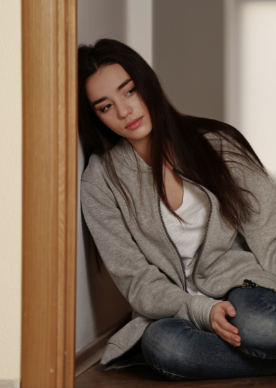 Woman leaning on wall looking depressed