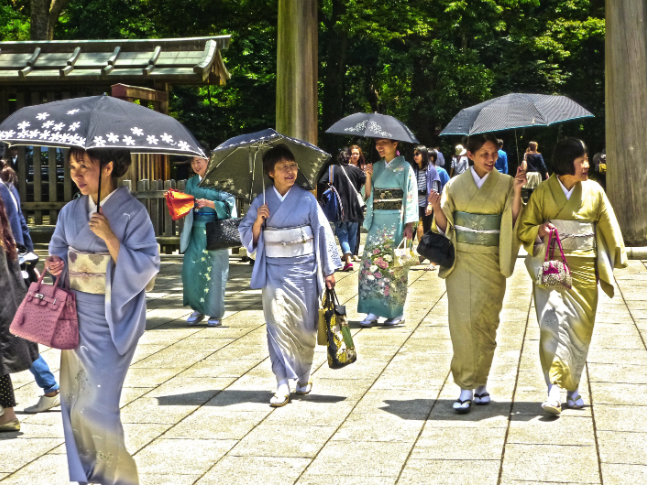 Asian women holding umbrellas and walking