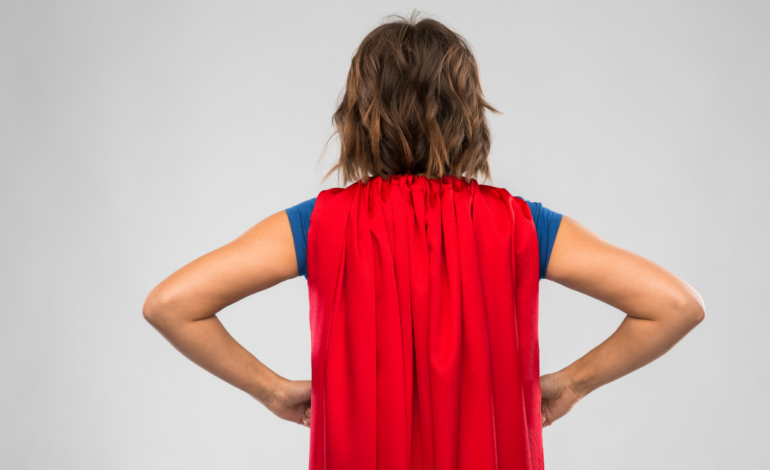 Women with hands on hips and wearing a red cape